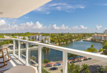 View of balcony in Mid-Beach in Miami Beach biscayne bay is observed, beach with the turquoise sea, modern buildings and towers, tropical and summer weather, blue sky with clouds
